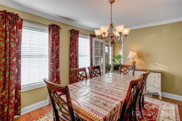 dining area featuring crown molding, a textured ceiling, and hardwood / wood-style flooring