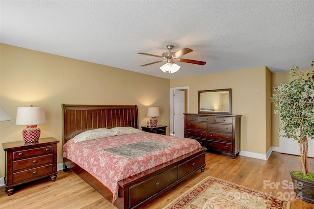 bedroom featuring ceiling fan, light hardwood / wood-style floors, and a textured ceiling