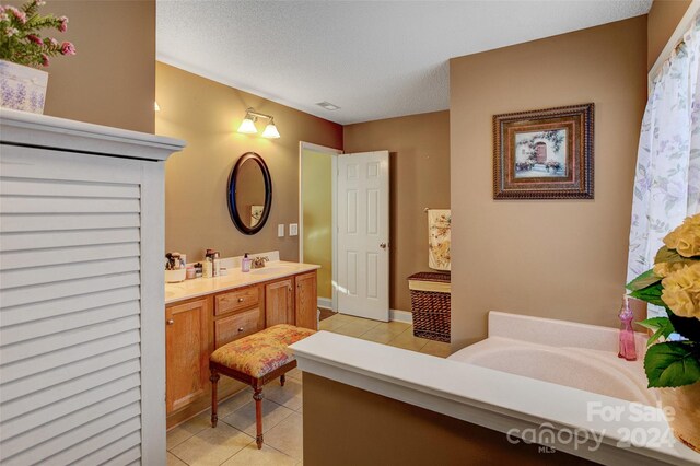 bathroom featuring vanity, a textured ceiling, and tile patterned flooring