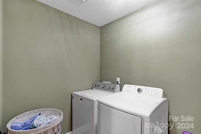 washroom featuring a textured ceiling and separate washer and dryer