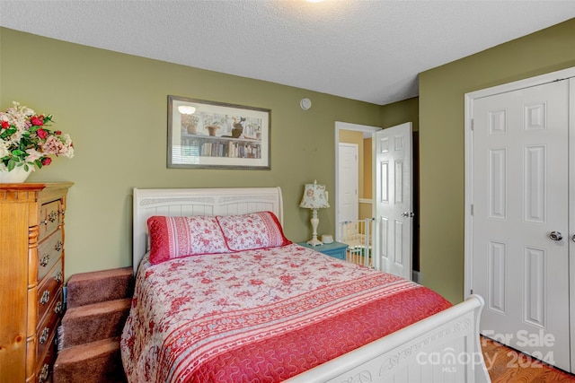 bedroom with hardwood / wood-style floors and a textured ceiling