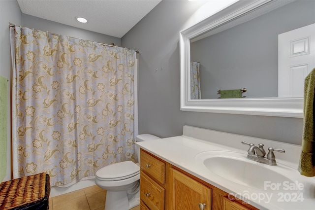 bathroom with tile patterned flooring, vanity, toilet, and a textured ceiling