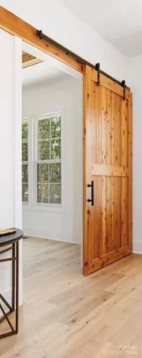 doorway to outside featuring a barn door and light hardwood / wood-style flooring