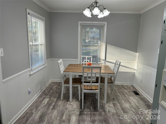 dining space featuring hardwood / wood-style floors, an inviting chandelier, and ornamental molding