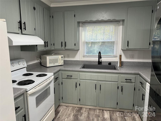 kitchen with white appliances, sink, and light hardwood / wood-style flooring