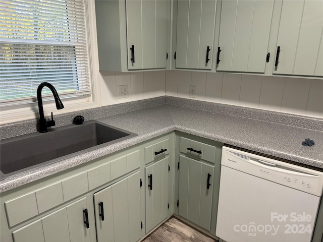 kitchen with light hardwood / wood-style flooring, sink, and white dishwasher