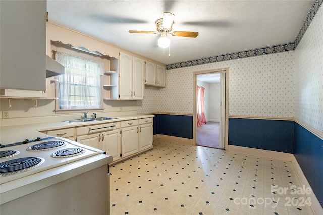 kitchen with white stove, sink, ceiling fan, a textured ceiling, and range hood