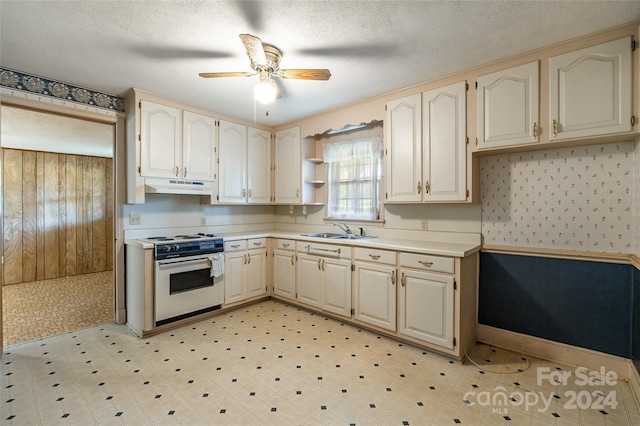 kitchen with a textured ceiling, ceiling fan, sink, and white stove