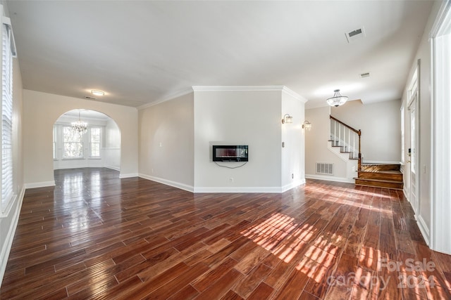 unfurnished living room with a notable chandelier, dark hardwood / wood-style floors, and crown molding