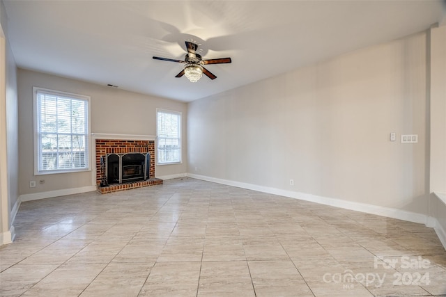 unfurnished living room featuring ceiling fan and a fireplace