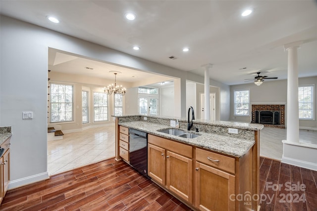 kitchen featuring ceiling fan with notable chandelier, dark wood-type flooring, sink, pendant lighting, and black dishwasher