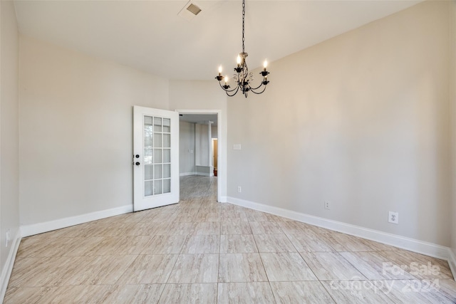 spare room featuring an inviting chandelier