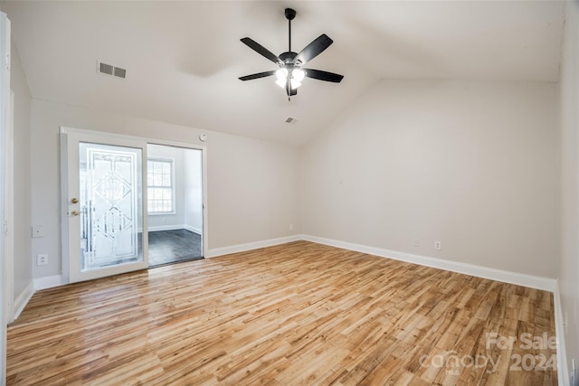 empty room featuring ceiling fan, light wood-type flooring, and vaulted ceiling