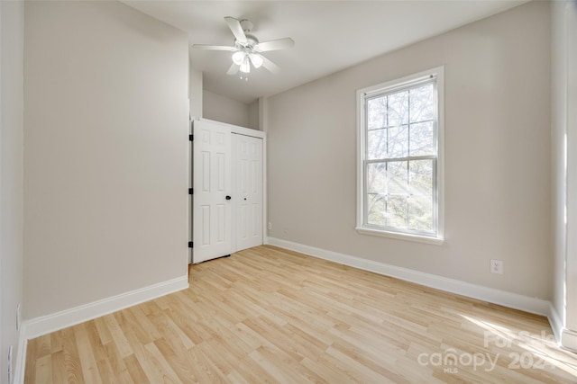 empty room featuring light wood-type flooring and ceiling fan