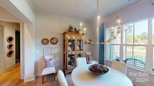 dining room with hardwood / wood-style floors and ornamental molding