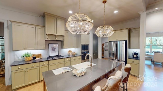 kitchen featuring appliances with stainless steel finishes, crown molding, pendant lighting, a center island with sink, and a chandelier