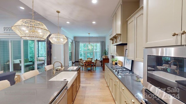 kitchen with sink, hanging light fixtures, tasteful backsplash, and a chandelier