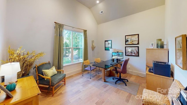 office area featuring high vaulted ceiling and light hardwood / wood-style flooring