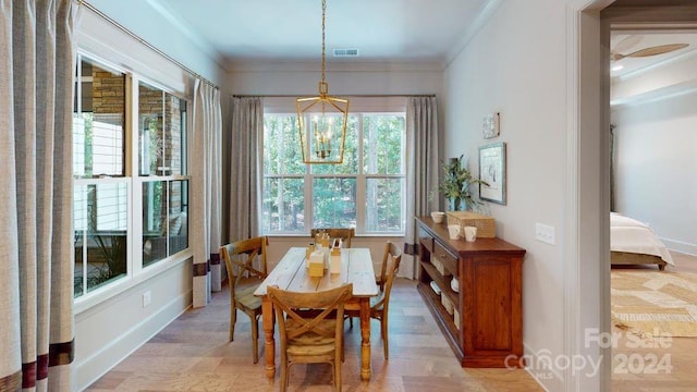 dining room with light hardwood / wood-style flooring and ornamental molding