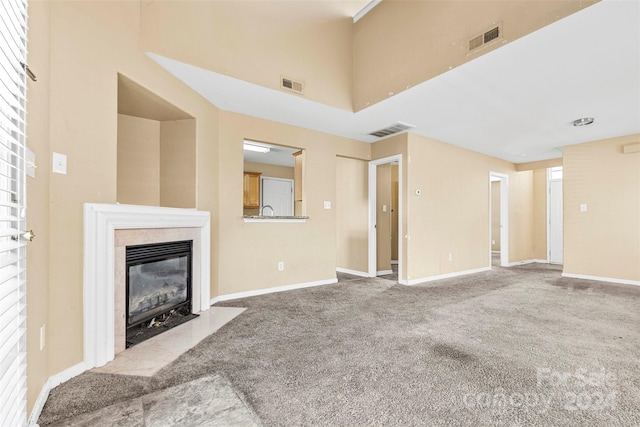 unfurnished living room with carpet floors and a high end fireplace