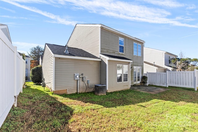 rear view of property featuring a yard and cooling unit