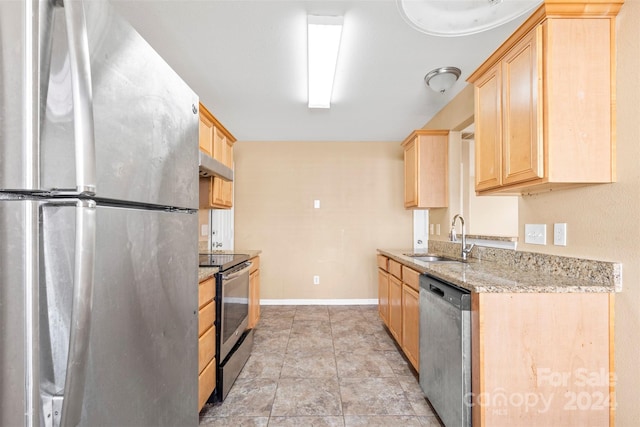 kitchen featuring light brown cabinetry, light stone counters, sink, and appliances with stainless steel finishes