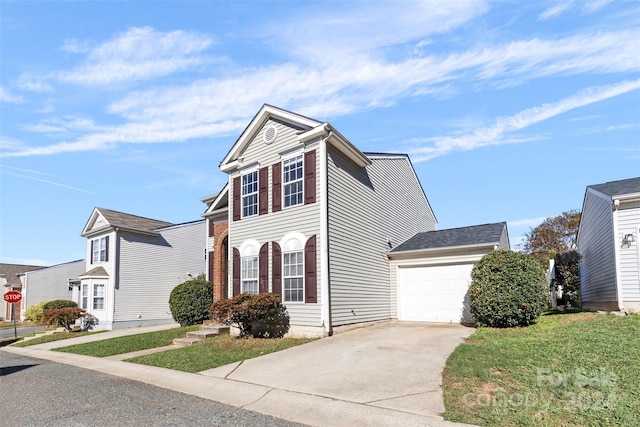 view of property with a front lawn and a garage