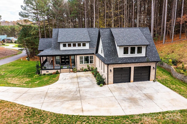 view of front of house with a porch, a garage, and a front lawn