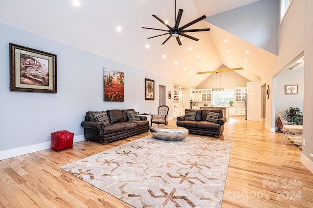 living room featuring hardwood / wood-style floors, high vaulted ceiling, and ceiling fan