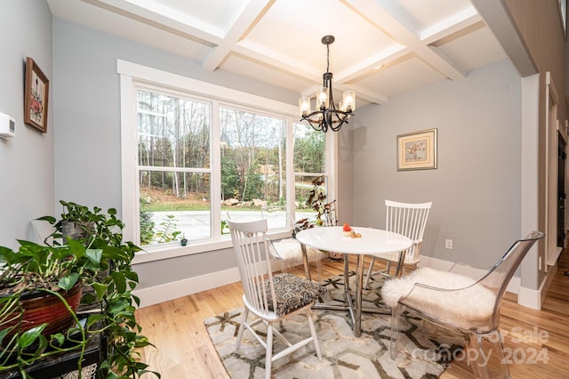 dining room with beamed ceiling, light hardwood / wood-style flooring, a wealth of natural light, and coffered ceiling