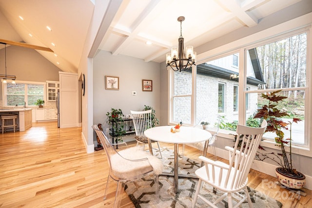 dining area with beamed ceiling, light hardwood / wood-style floors, and a chandelier