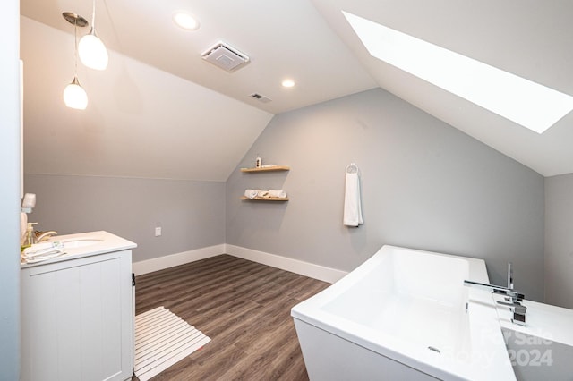 interior space with dark hardwood / wood-style floors, sink, and a skylight