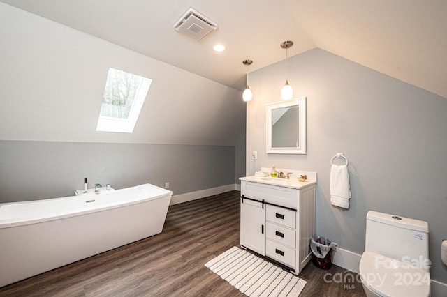 bathroom with a bathtub, wood-type flooring, toilet, vaulted ceiling with skylight, and vanity