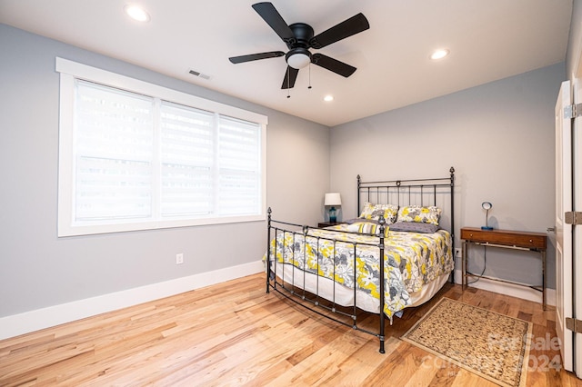 bedroom with multiple windows, ceiling fan, and light hardwood / wood-style flooring