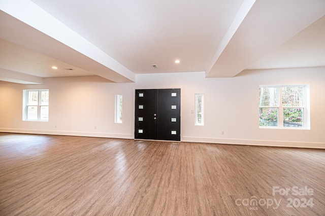 unfurnished living room featuring wood-type flooring and a healthy amount of sunlight