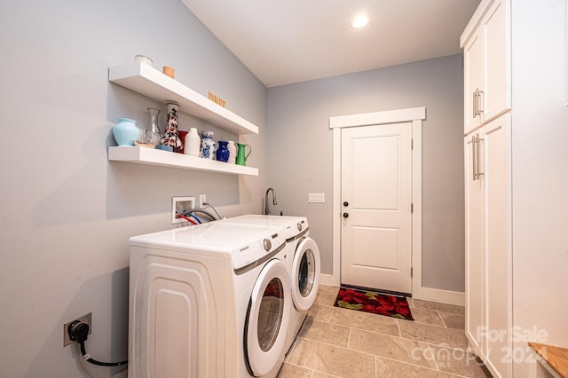 washroom with cabinets and washing machine and dryer