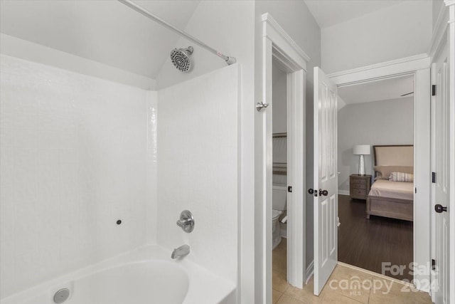 bathroom featuring hardwood / wood-style floors, lofted ceiling, and tub / shower combination