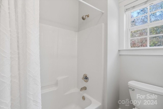 bathroom featuring shower / bath combination with curtain and toilet