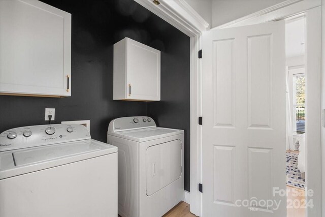 washroom with cabinets and washing machine and dryer