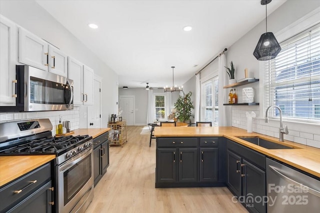 8225 Ballymore Ct, Huntersville, NC 28078 - kitchen with appliances with stainless steel finishes, wooden counters, a sink, light wood-style floors, and tasteful backsplash