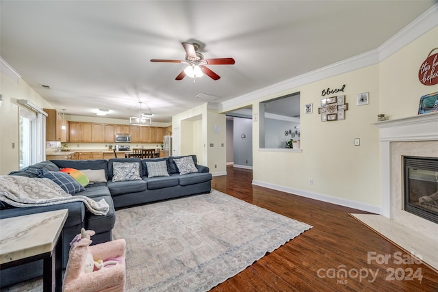 living room featuring a high end fireplace, dark hardwood / wood-style flooring, ceiling fan, and ornamental molding