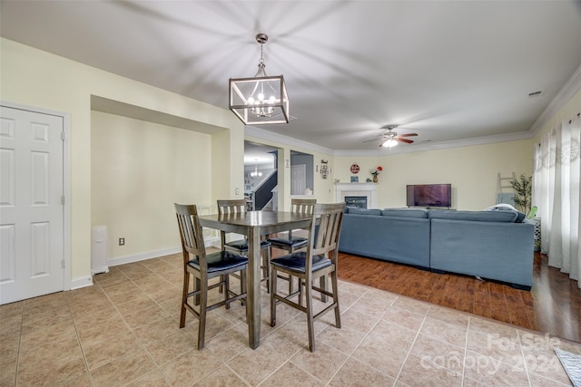 dining room featuring crown molding, light hardwood / wood-style flooring, and ceiling fan with notable chandelier