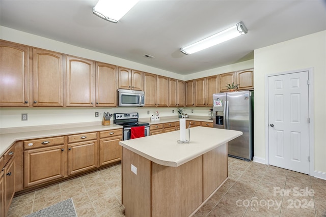 kitchen featuring a kitchen island, light tile patterned flooring, and stainless steel appliances