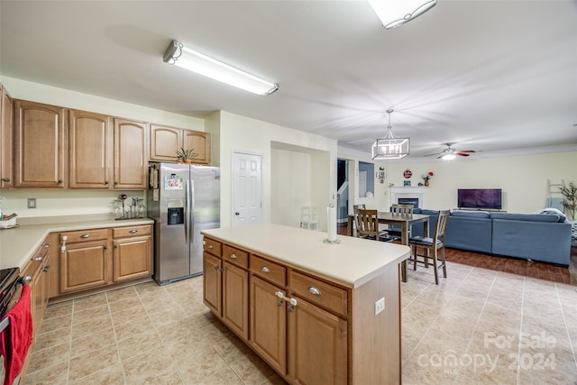 kitchen with stove, ceiling fan, stainless steel fridge, decorative light fixtures, and a kitchen island