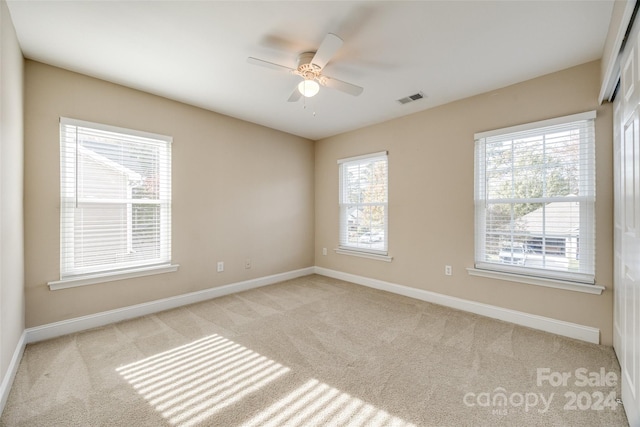 carpeted spare room featuring ceiling fan