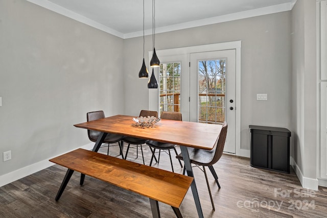 dining space featuring wood-type flooring and ornamental molding