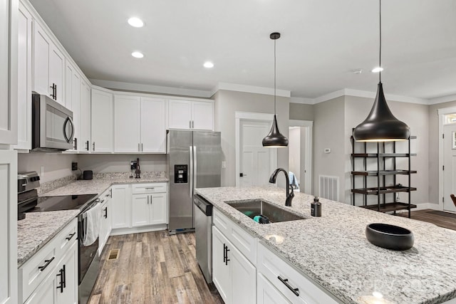 kitchen featuring sink, white cabinets, appliances with stainless steel finishes, a kitchen island with sink, and wood-type flooring