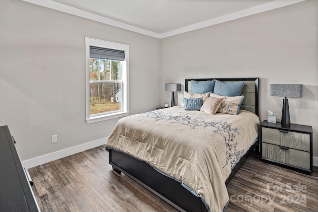 bedroom with ornamental molding and dark hardwood / wood-style floors