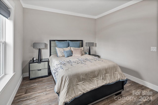 bedroom with crown molding and dark hardwood / wood-style floors