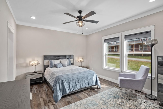 bedroom with ornamental molding, ceiling fan, and dark wood-type flooring